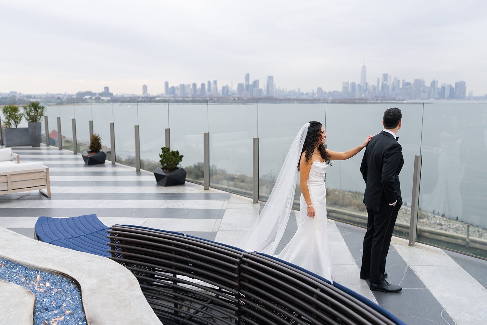 Ellie walks up to Harrison for their first look on the Hudson House terrace, Manhattan across the river
