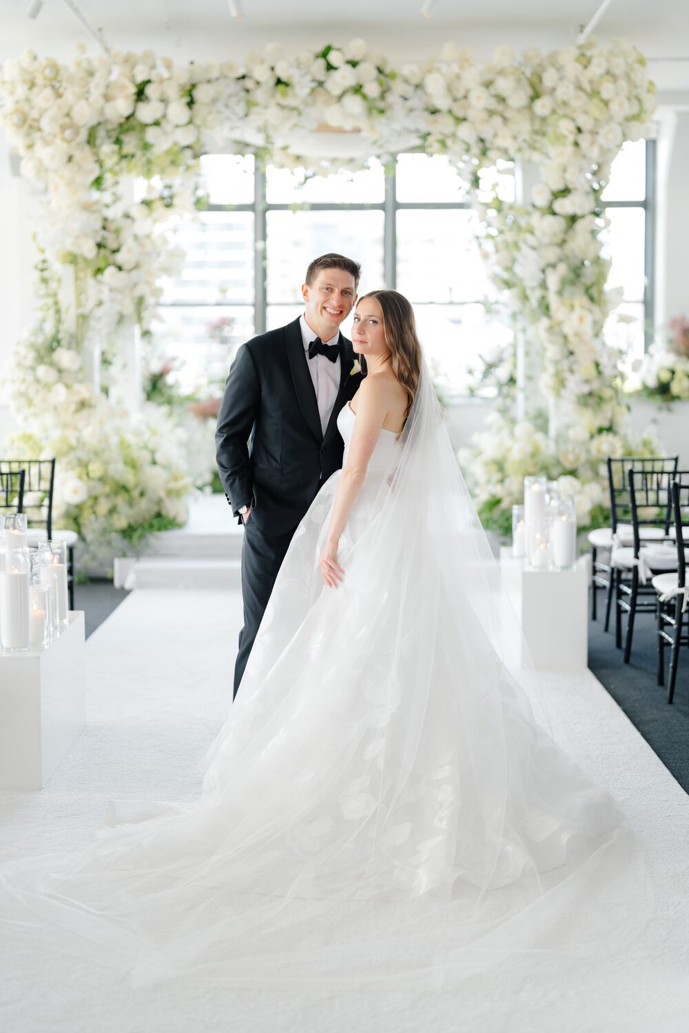 Wedding at Tribeca Rooftop + 360° — couple under floral chuppah window light